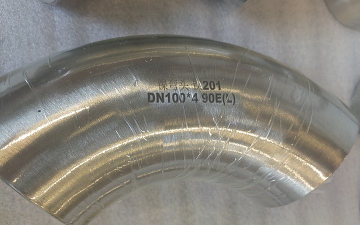 Alloy elbow showing stamped heat number on the outside surface